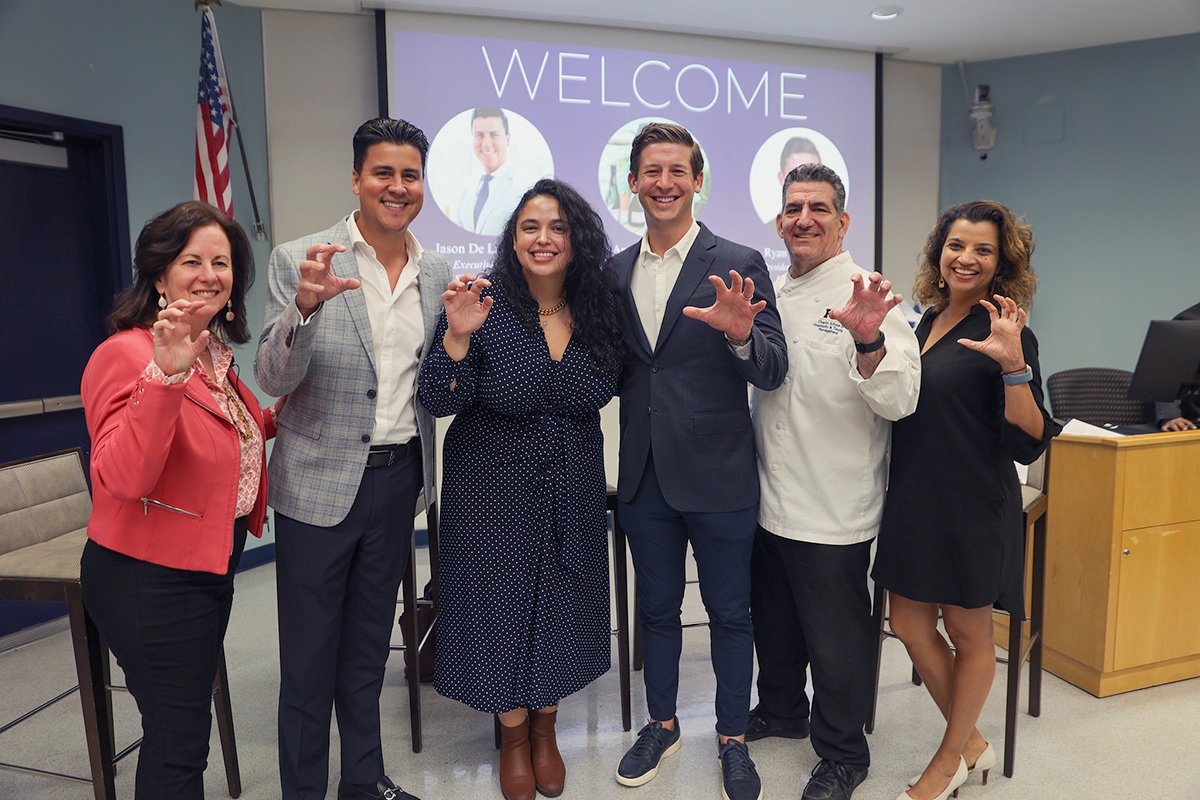 Event attendees showing the paw sign